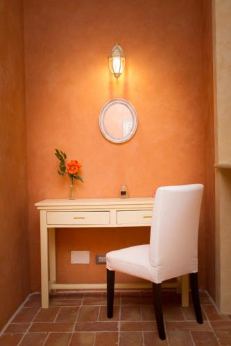 a desk with a white chair and a mirror at Tenuta Isola in Langosco