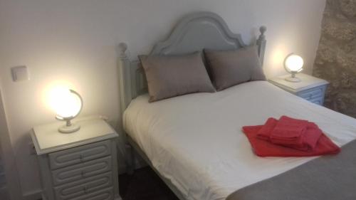 una camera da letto con un letto bianco con due lampade di Casa do Chico a Vieira do Minho