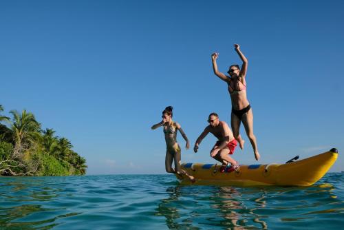 a group of people jumping off a paddle board into the water at Athiriveli in Thoddoo