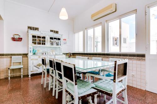 a kitchen with a glass table and chairs at À da Avó -The Guesthouse in Faro