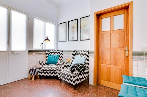 a room with two chairs and a door at À da Avó -The Guesthouse in Faro