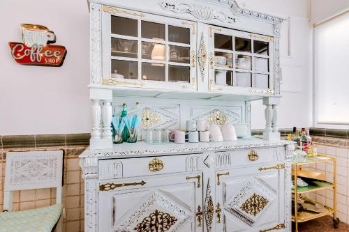 um armário branco numa cozinha com uma prateleira em À da Avó -The Guesthouse em Faro