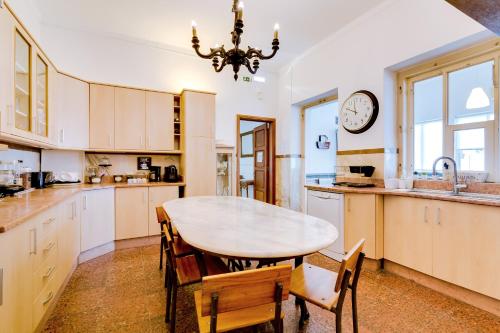 a kitchen with a table and a clock on the wall at À da Avó -The Guesthouse in Faro