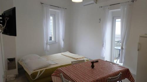 a white room with a bed and two windows at Josipa in Crikvenica
