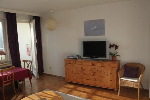 een woonkamer met een televisie op een houten dressoir bij Ferienwohnung da Luz in Travemünde