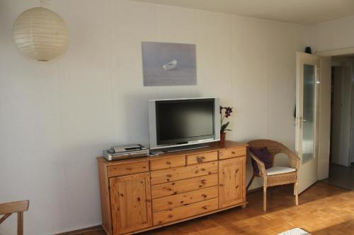 een televisie op een houten dressoir in een kamer bij Ferienwohnung da Luz in Travemünde