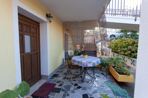 Habitación con mesa y balcón con plantas. en Apartments Topic & Krk central location, en Krk