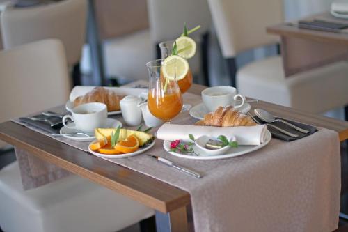 een tafel met een dienblad met ontbijtproducten en sinaasappelsap bij Rooms Villa Oasiss in Pula
