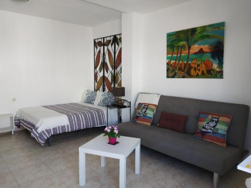 a living room with a couch and a bed at Casa Luisa in Caleta De Fuste