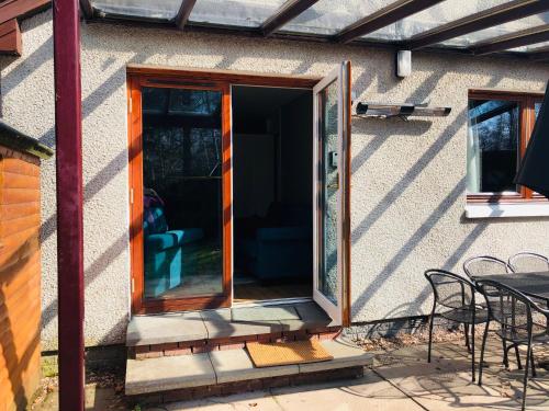 an open door of a house with a patio at Linmore in Aviemore