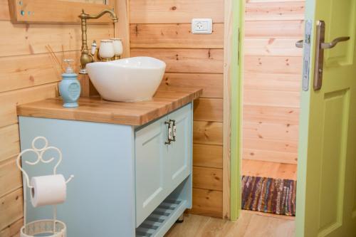 ein Badezimmer mit einem Waschbecken an einer Holzwand in der Unterkunft Anat's Cabin הצימר של ענת in Kefar H̱ananya