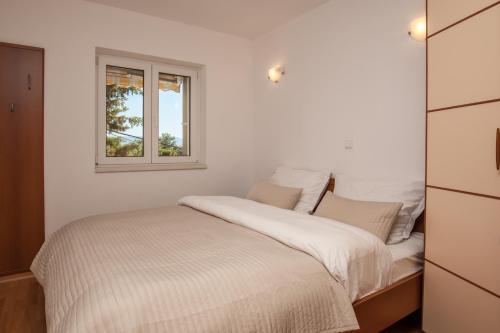 Habitación blanca con cama y ventana en Villa Dalmatia Apartments, en Bol