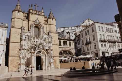 a church in a city with people walking around it at Casa da Moeda by Escapadinha Portuguesa in Coimbra