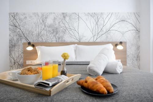 a tray of food and drinks on a bed at Aspasios Atocha Apartments in Madrid