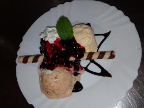 a dessert on a white plate with ice cream and berries at Penzión Racibor in Oravský Podzámok