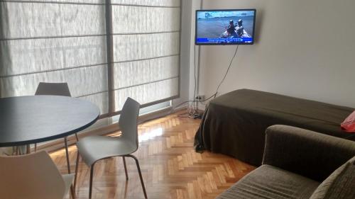 Habitación con cama, mesa y TV. en Confortable Apartment en Buenos Aires