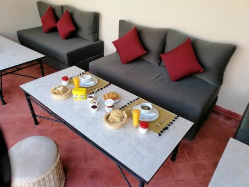 马拉喀什里亚德幻影旅馆的客厅里有一张沙发和一张咖啡桌。