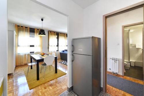 a kitchen and dining room with a refrigerator and a table at Apartment Place4U in Zagreb