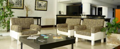 a living room with two chairs and a coffee table at Hotel Corbel Superior by bund in Mar del Plata