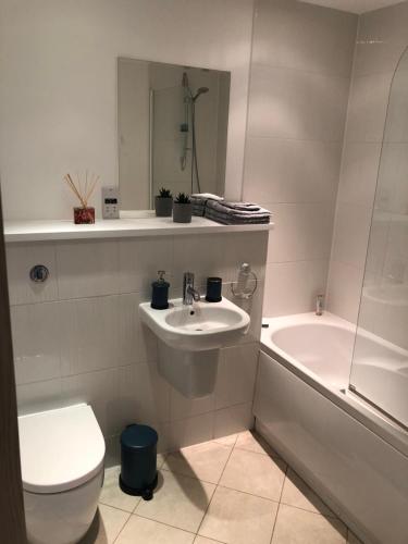 a bathroom with a toilet and a sink and a tub at Quayside Apartment in Cardiff Bay in Cardiff