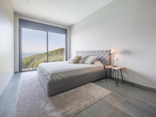 biała sypialnia z łóżkiem i dużym oknem w obiekcie TarracoHomes, Exclusive tamarit villa w mieście Tamarit
