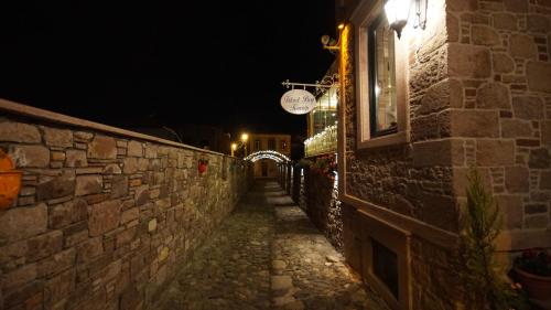 an alley with a stone wall at night at Fikretbey Konağı in Ayvalık