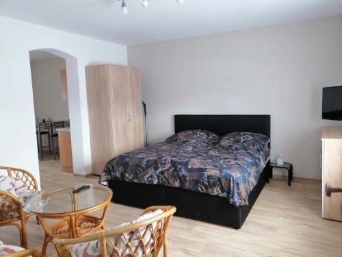 1 dormitorio con 1 cama, mesa y sillas en Ferienwohnung im Spreewald "Gina", en Vetschau