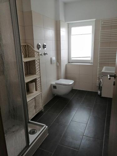 ein Bad mit einer Dusche, einem WC und einem Fenster in der Unterkunft Ferienwohnung im Spreewald "Gina" in Vetschau