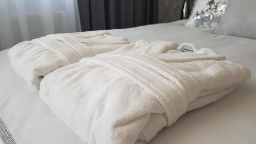 een witte handdoek bovenop een bed bij Silver Apartaments in Piła