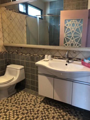 a bathroom with a sink and a toilet and a mirror at Beach Shoes Villa in Yanliau
