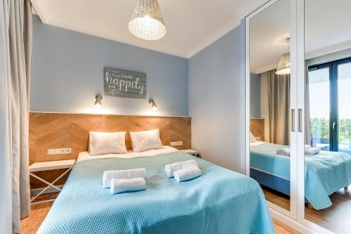 a bedroom with two beds and a mirror at Lion Apartments - Naviflat Apartament Okrzei 21 in Sopot
