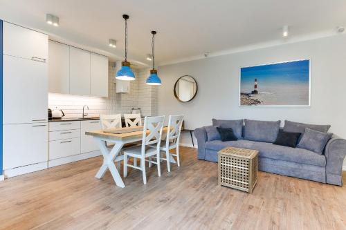 kuchnia i salon z niebieską kanapą i stołem w obiekcie Naviflat- Luxury Sopot Residence Okrzei 21 by Lion Apartments w mieście Sopot