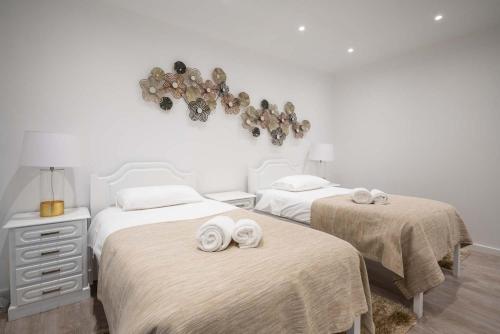 a bedroom with two beds with towels on them at Apartamento Pita by HR Madeira in Funchal