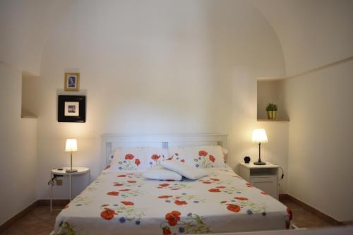 una camera da letto con un letto fiorito di Gorgo Rinaldi - Locazioni brevi a Monopoli