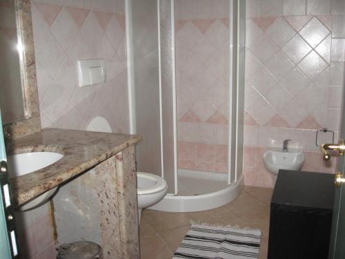 a bathroom with a shower and a toilet and a sink at Casa Porto Corallo in Villaputzu