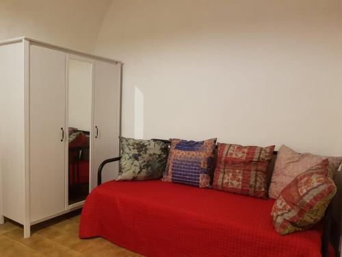 a couch with a red blanket and pillows on it at Masseria Vivi il Salento in Santa Caterina di Nardò