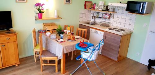 a small kitchen with a table and a kitchen with a stove at APPT 3* LE HAUT DES LACS in Xonrupt-Longemer
