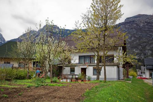 a white house with mountains in the background at Bovec Holiday House in Bovec