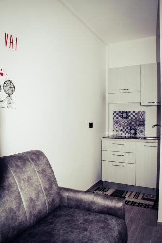 a living room with a couch and a kitchen at B&B Alto Salento - Pool and Sun in Pulsano