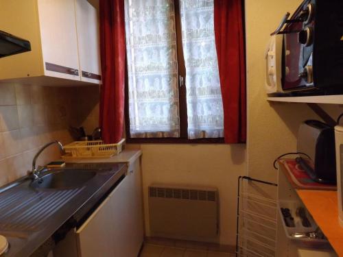 une petite cuisine avec un évier et une fenêtre dans l'établissement Studio n°3, agréable et bien situé, à Amélie-les-Bains-Palalda
