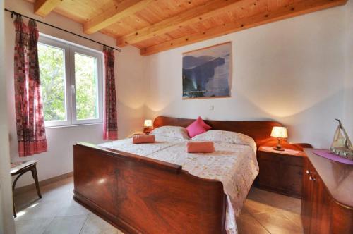 una camera con un grande letto in legno e una finestra di Villa Carmen a Sali (Sale)