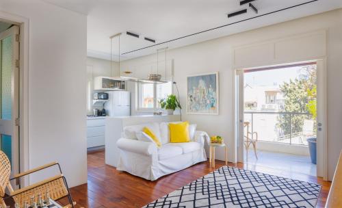 a white living room with a white couch and yellow pillows at A luxury Suite in Chen Boulevard in Tel Aviv