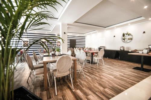 a dining room with wooden floors and chairs and tables at New Corner in Niechorze