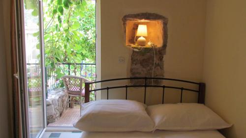 a bedroom with a bed with a lamp and a window at Apartments Senko in Trpanj