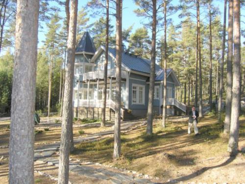 a person standing in front of a house in the woods at Holiday Home Villa merituuli by Interhome in Haverö