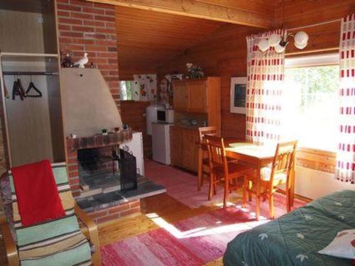 cocina y comedor con chimenea y mesa en Holiday Home Raanumökki 4 by Interhome, en Lampsijärvi