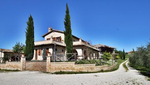 a house with two trees in front of a road at Agriturismo alla Solagna in Colli del Tronto
