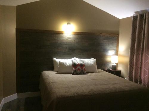 a bedroom with a bed with a large wooden headboard at Villegiature Deux Rivieres Resort in Tracadie