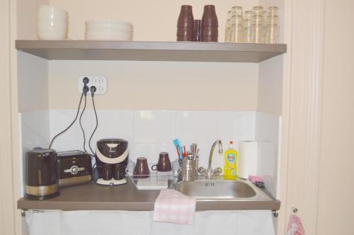 a kitchen counter with a sink and some dishes at Synagogue Central Guest House in Budapest