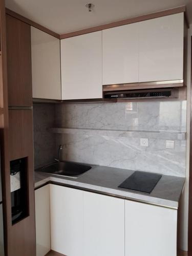 a kitchen with white cabinets and a counter top at M-Town Signature Gading Serpong by J`s Luxury Apartment in Pumpangsineng